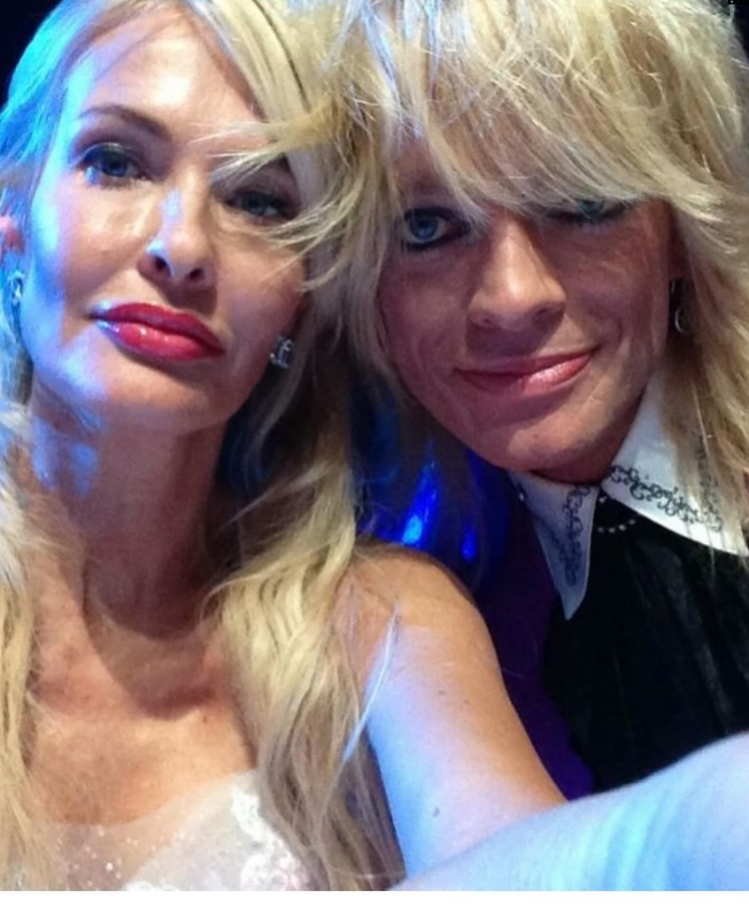 Michael Monroe ja Johanna Fagerholm poseeraavat lähekkäin sinisessä valaistuksessa hääpäivänään.